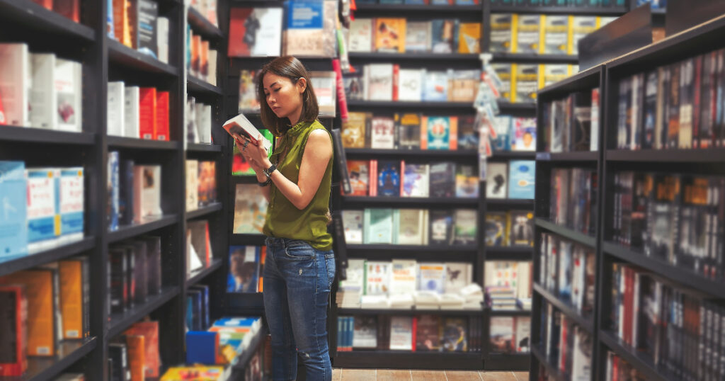 Amazon Marketing Services For Authors - Woman In A Book Store Reading The Back Cover Of A Book 